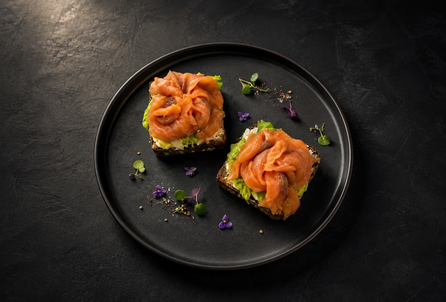 The same salmon sushi bites presented in a dramatic studio-quality restaurant photograph